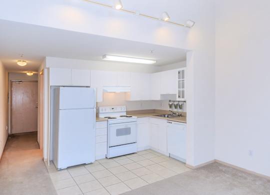 A kitchen with white appliances and a white refrigerator.