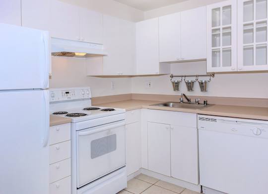 A white kitchen with a refrigerator, stove, and dishwasher.