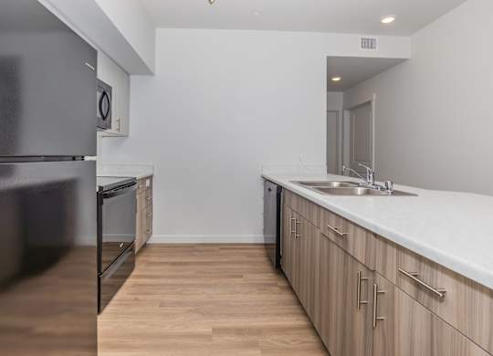 A kitchen with wooden floors and white countertops.