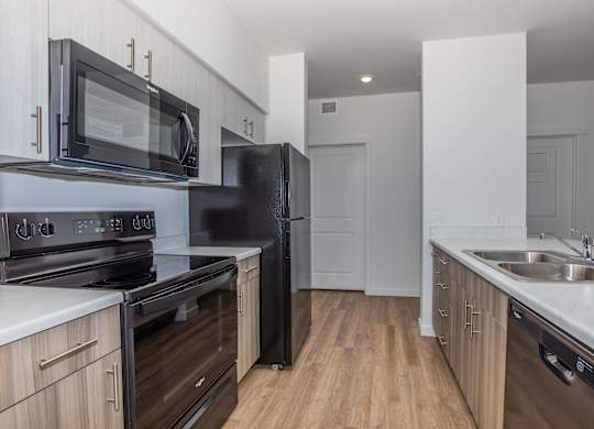 A kitchen with black appliances and wooden cabinets.