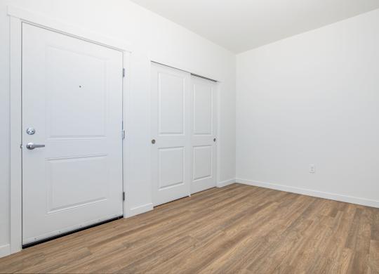 A room with two doors and wooden flooring.