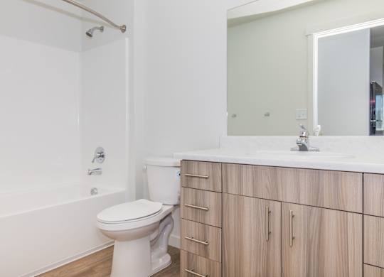 A white toilet in a bathroom with wooden cabinets.