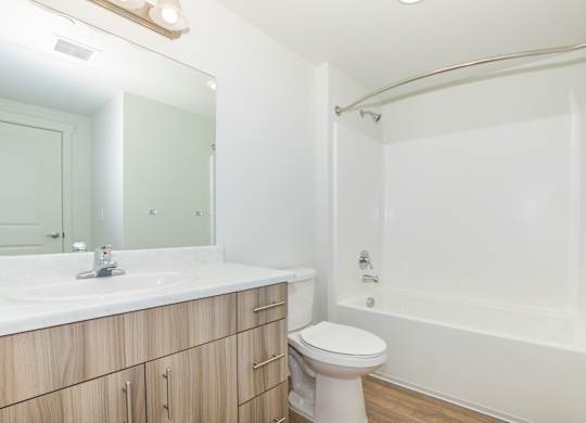 A white bathroom with a sink, toilet, and bathtub.