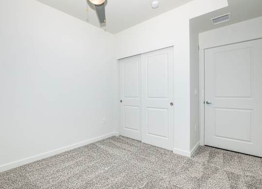 A room with two doors and a ceiling fan.
