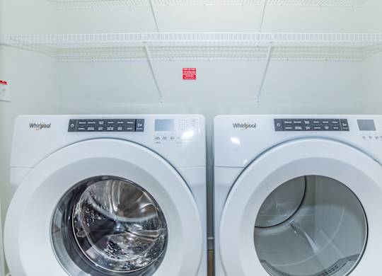 Two Whirlpool washing machines are side by side.