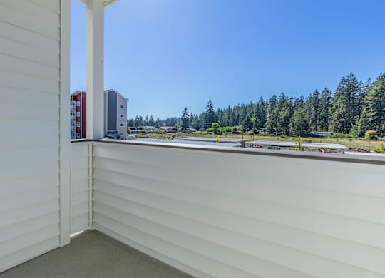 A view from a window of a white building with a red and white building in the distance.