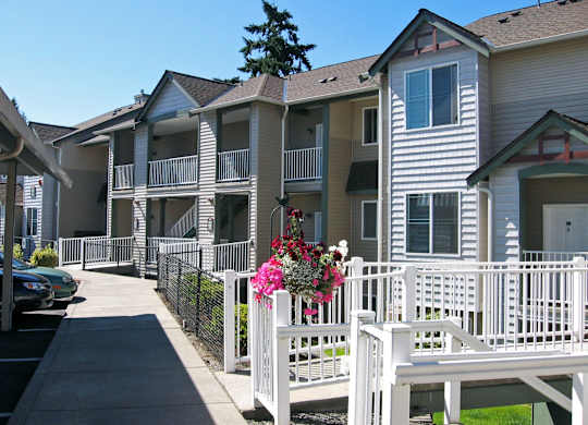 A white picket fence with a bench and flowers on it.