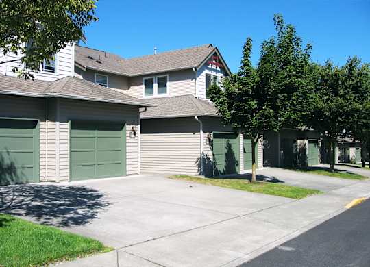 A row of houses with green garage doors.