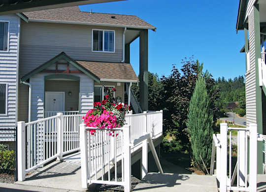 A house with a white fence and pink flowers.