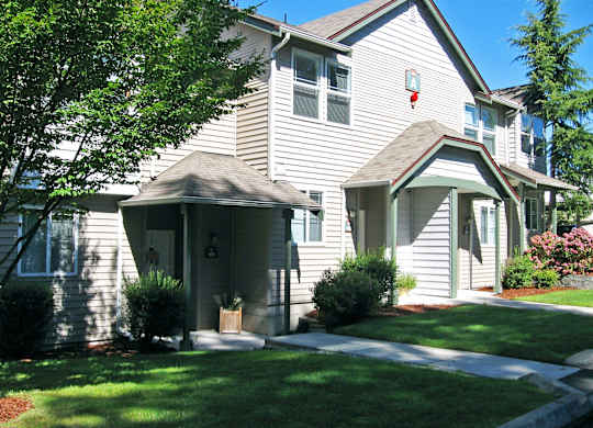 A house with a grey siding and a brown roof.