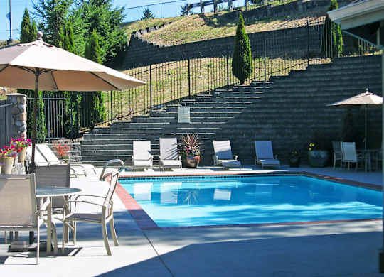 A pool with a table and chairs around it.