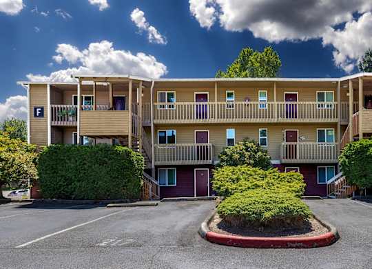 A large apartment complex with a parking lot in front.