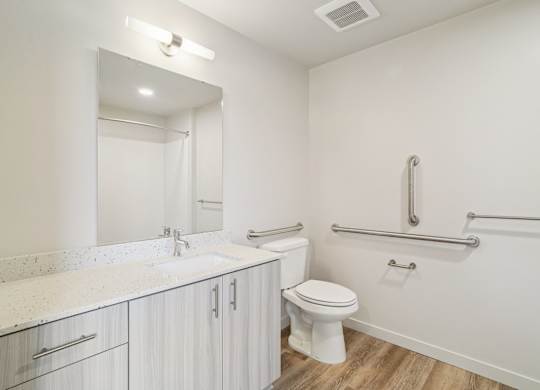 A white bathroom with a toilet, sink, and mirror.