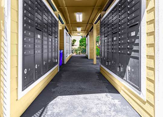 A long hallway with mailboxes on the wall.