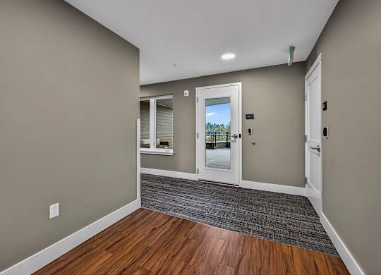A hallway with a wooden floor and white doors.