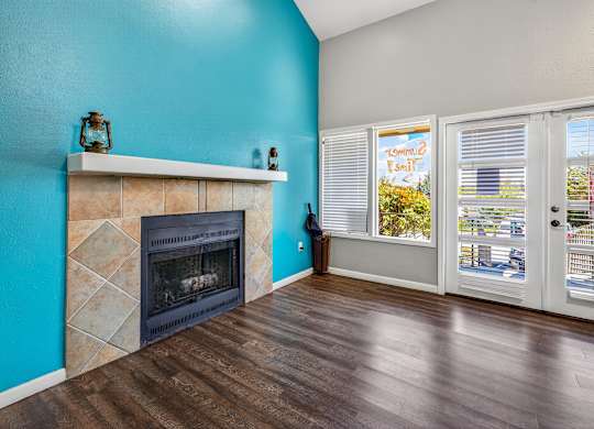 A room with a fireplace and a window with blinds.