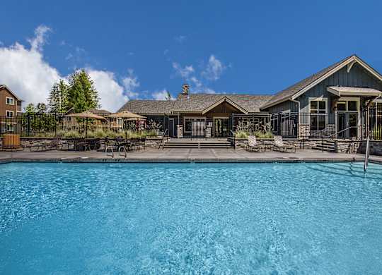 A large swimming pool in front of a house.