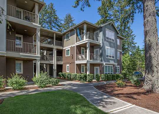 A large apartment complex with a green lawn in front.