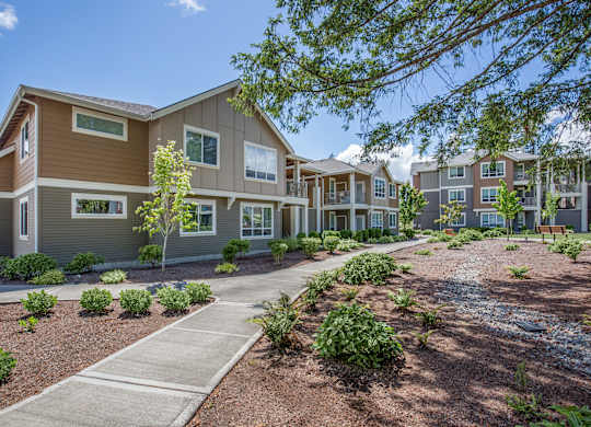 A modern apartment complex with a well-maintained landscaped courtyard.