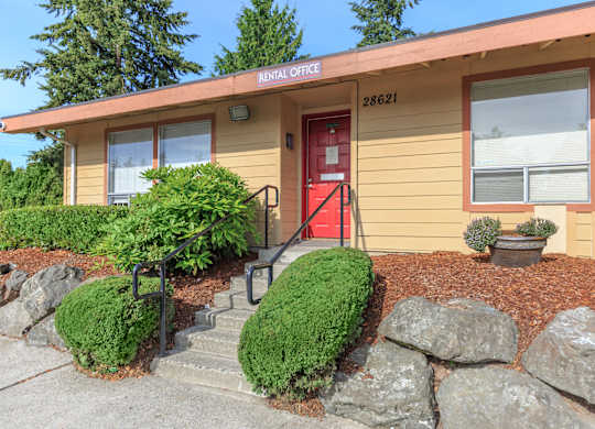 A building with a red door and a sign that says "Rental Office" on the top.