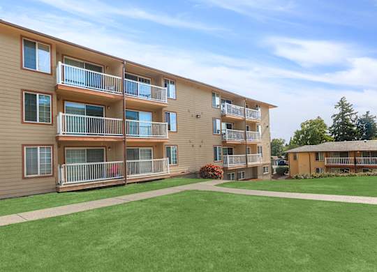 A large grassy area in front of apartment buildings.