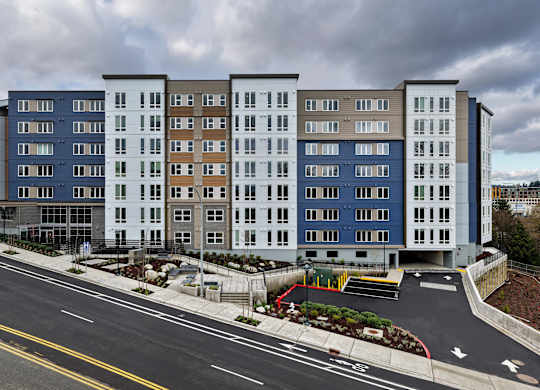 A large multi-story building with a parking lot in front.