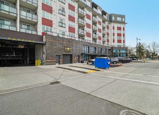 A parking garage is in front of a multi-story building.