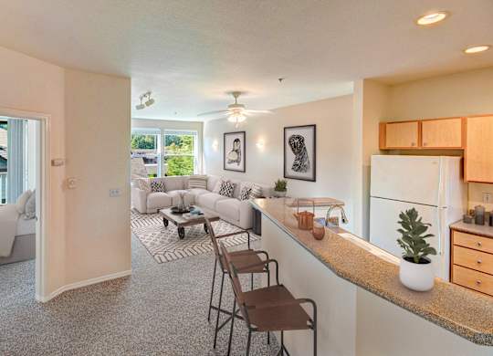 A well-lit, modern kitchen and living room with a dining area.