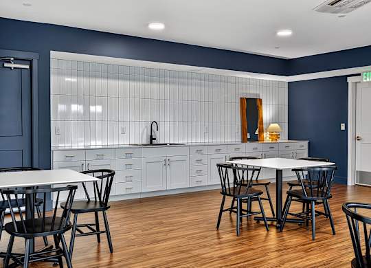 A kitchen with a table and chairs in front of a blue wall.