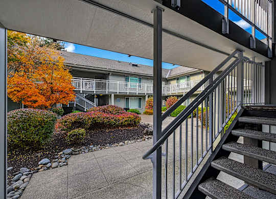 A staircase with a metal railing leads to a building.