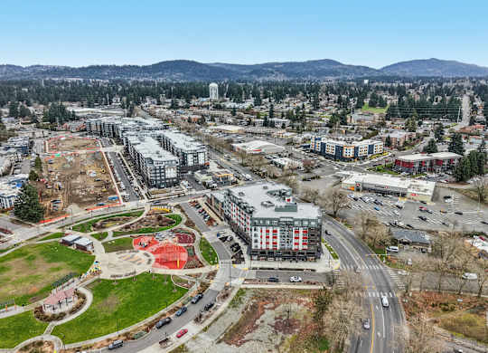 A cityscape with a large building in the center and a road running through it.