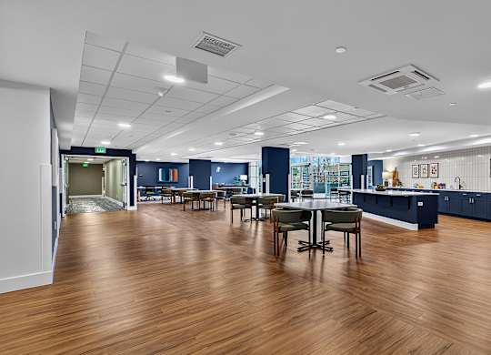 A large open space with wooden floors and a long table with chairs.