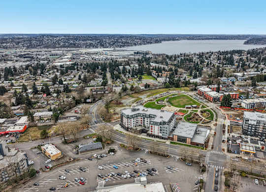 A view of a city with a large parking lot in the foreground and a river in the background.