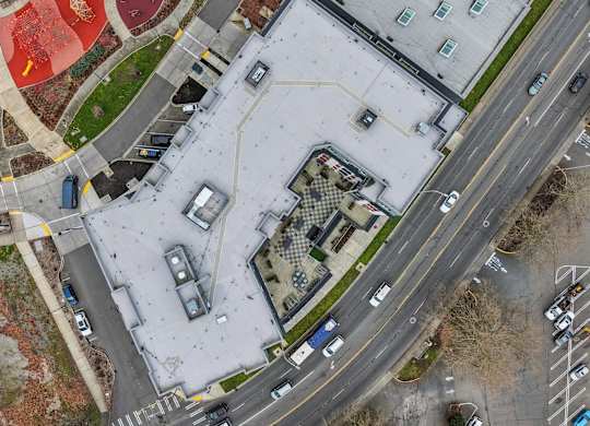 An aerial view of a parking lot with cars and a building.