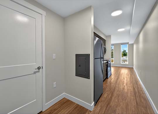 A kitchen with a refrigerator and a door.