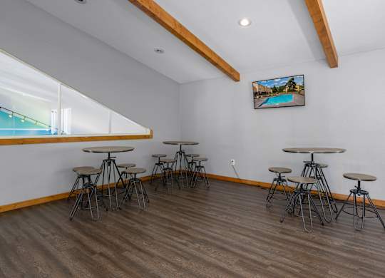 A room with a long table and chairs and a picture of a pool on the wall.
