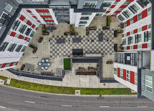 A top down view of a courtyard surrounded by buildings with a checkerboard pattern.