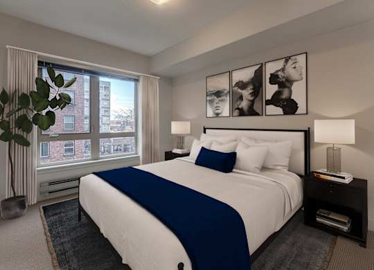 A bedroom with a large bed and a window overlooking a city.