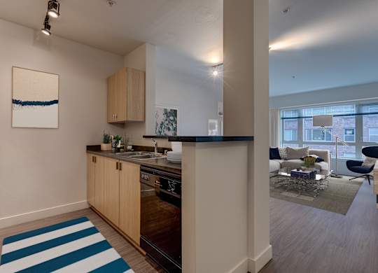 A kitchen with a blue and white striped rug on the floor.