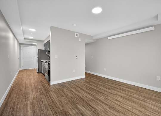 A kitchen area with wood flooring and white walls.
