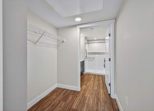 A hallway with a wooden floor and white walls.