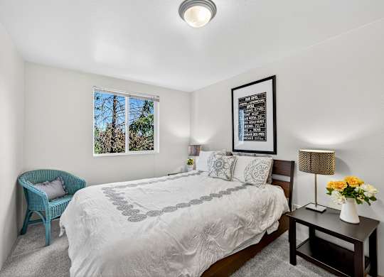A bedroom with a large bed and a blue chair.