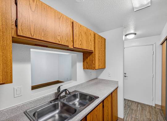A kitchen with wooden cabinets and a white fridge.