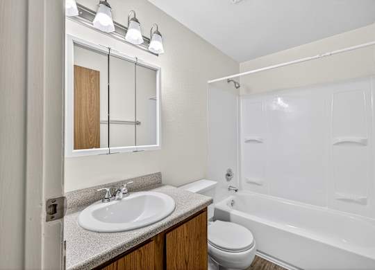 A white bathroom with a sink, toilet, and bathtub.