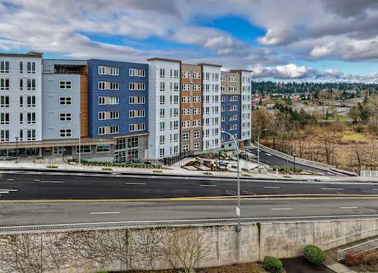 A large apartment complex with a parking lot in front.