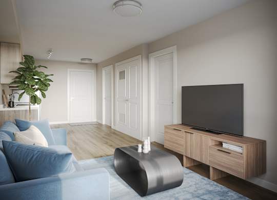 A modern living room with a blue sofa and a television on a wooden stand.