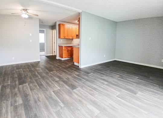 A room with wooden flooring and a ceiling fan.