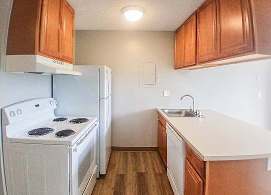 A white stove and oven in a kitchen with wooden cabinets.