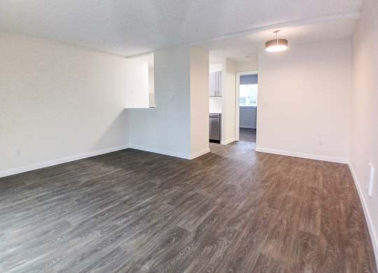 A room with wooden flooring and white walls.