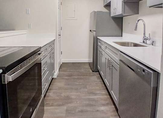 A kitchen with a stainless steel dishwasher and oven.